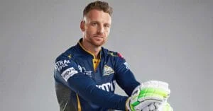 Close-up of a cricket goalkeeper in uniform with gloves, ready for play.
