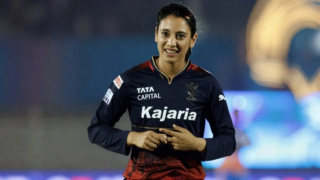 Smriti Mandhana smiling during a cricket match, showcasing her cricket skills.