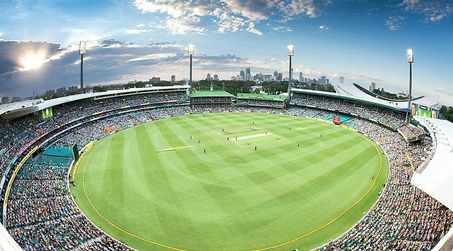 Ashes 2025–26: England Announce Strong XII for Crucial Fifth Test Cricket stadium filled with spectators during a match, under a bright sky with city skyline in the b.