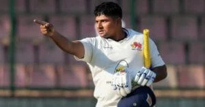 Cricket player celebrating with a pointing gesture during a match.